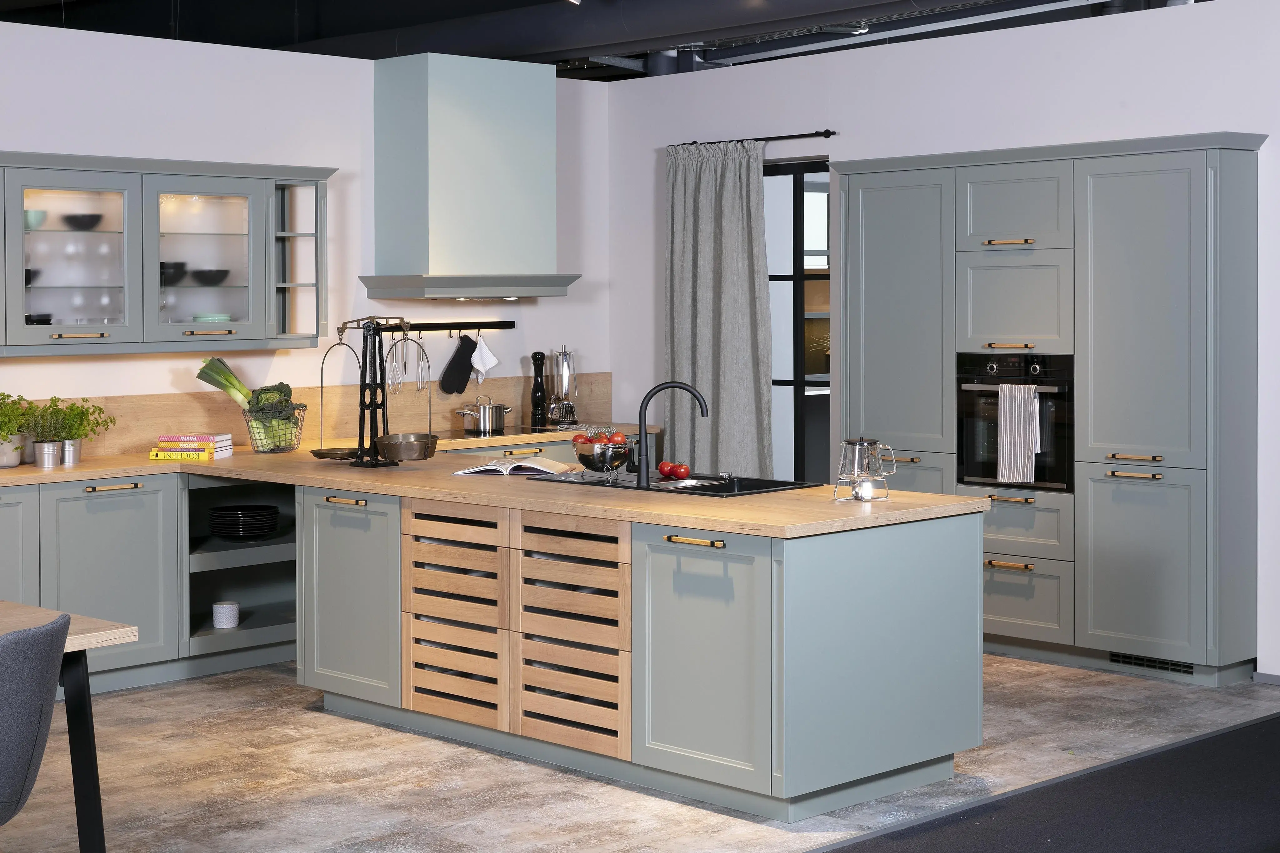 Grüne Landhausküche mit Holzelementen und einer Holzarbeitsplatte